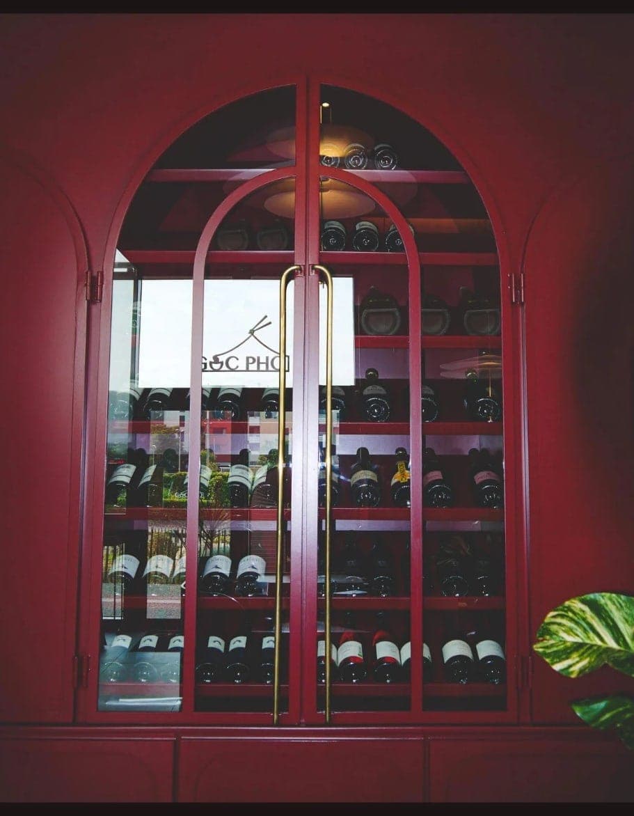 La porte vitrée de la cave, l’enseigne de Gốc Phở gravée sur le verre